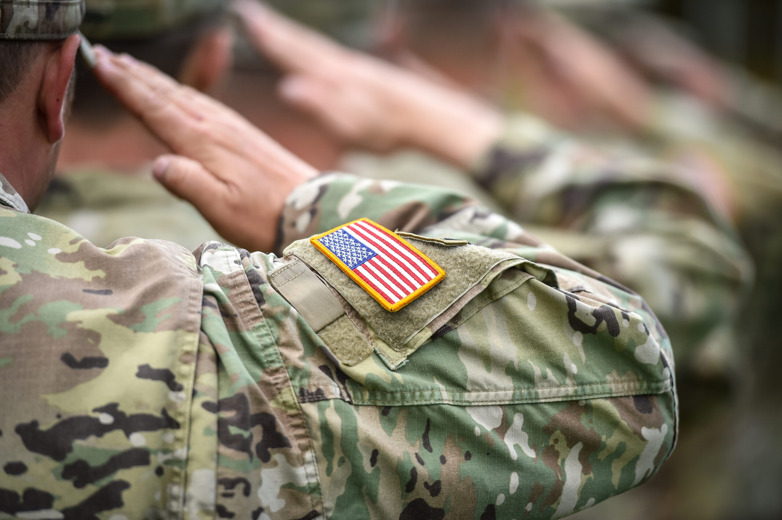 Detail shot with american flag on soldier uniform, giving the honor salute during military ceremony