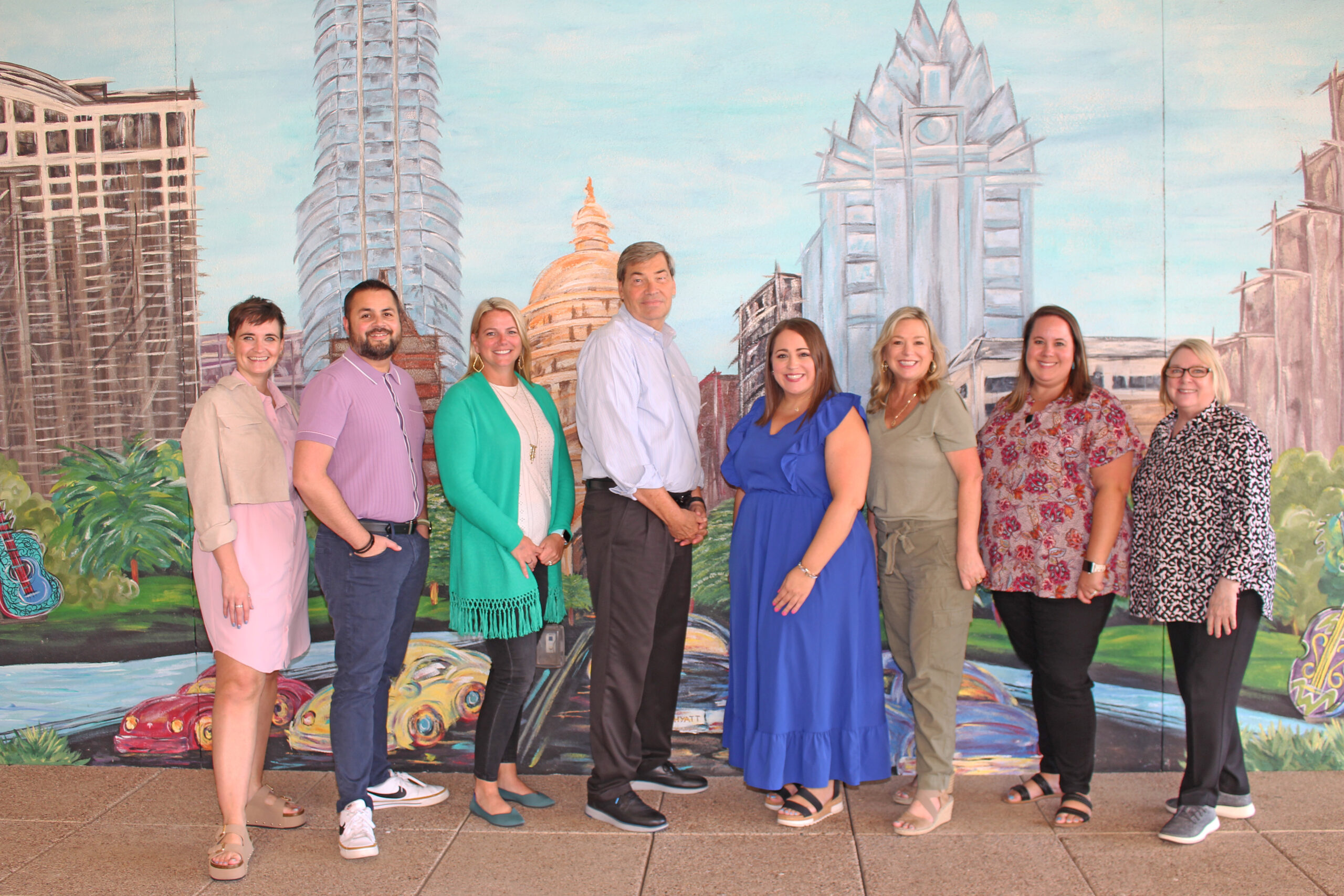 Visit Plano team at TACVB Annual Conference in front of a mural of Austin, TX