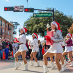 Plano, TX Holiday Event Guide - Holiday Parade drill team marching with presents